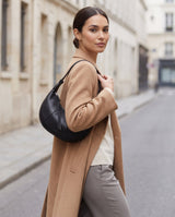 Aubrine Bernadette Crescent Bag in Black, worn on the shoulder